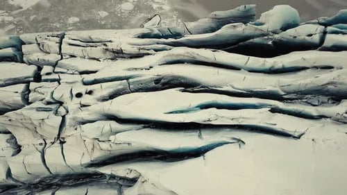 Glacier tongue in Iceland filmed by drone with different cinematic movements, showing a cloudy, dram