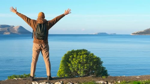 Traveler Enjoying Scenic Ocean View with Open Arms