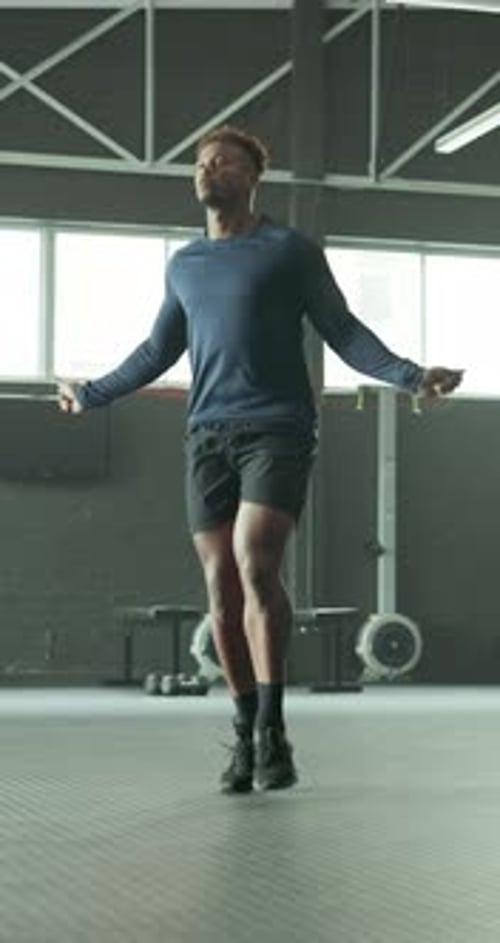 Man, exercise and skipping in gym for fitness, improve coordination or cardio training