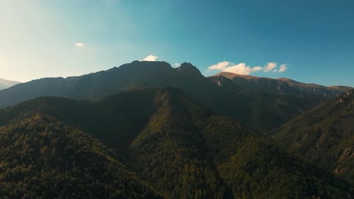 Drone rising above a ridge on the rocky mountains.