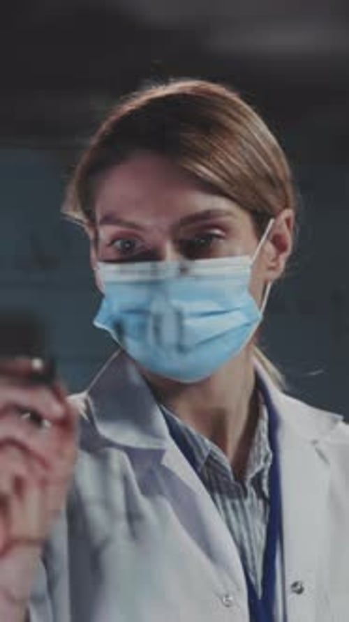 Médecin concentré marquant avec précision les scans diagnostiques sur une surface transparente en laboratoire clinique