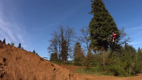 Motocross rider jumps dirt bike on motocross track