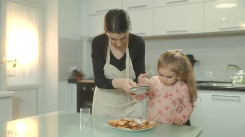 Woman and Child Baking Cookies Together at Home