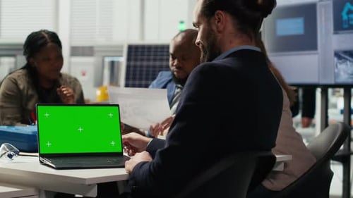 Factory Manager Works on Facility Upgrades Schematic Using Mockup Laptop
