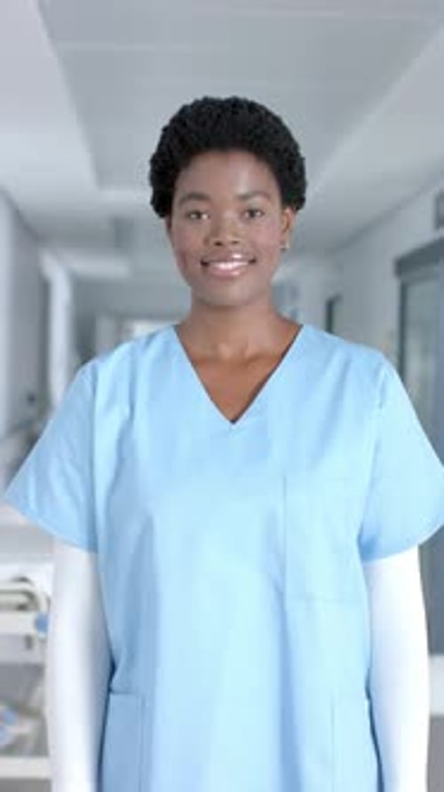 Smiling Healthcare Worker in a Hospital Corridor