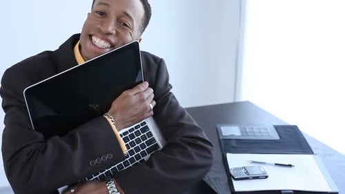Happy Man Hugging Laptop in Office Close-Up
