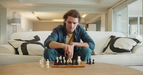 Young Adult Playing Chess at Home on Couch