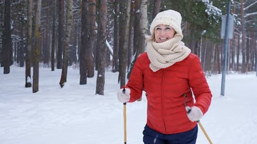 Woman Cross-Country Skiing in Snowy Winter Forest