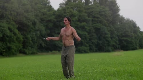A Man is Energetically Skipping Rope in a Lush Field Embraced By Nature