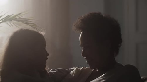 Woman Interacting With Child on Sofa Indoors