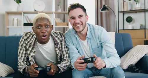 Two Friends Playing Video Games on the Couch