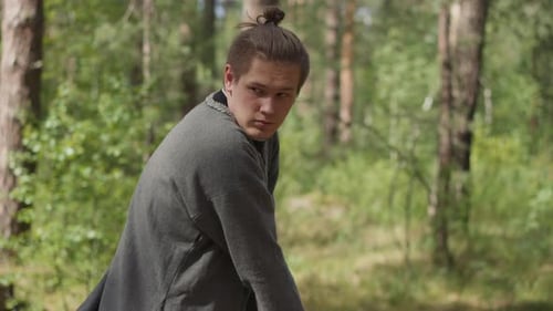 Man Training with Sword in Forest