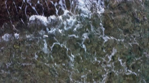 Low flyover ocean waves foaming and crushing on shore with colorful coral rock. Amazing 6k footage d