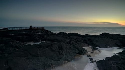 Romantic Couple Watching Beautiful Sunset By The Ocean. wide shot