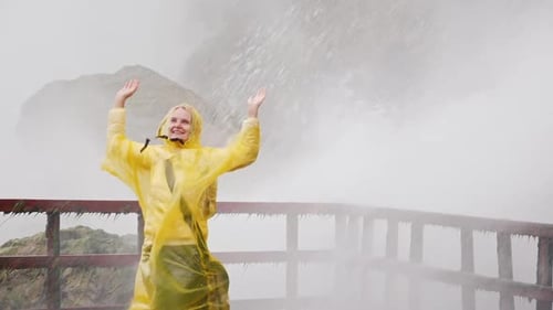 Woman Under the Streams of Niagara Falls Water Rejoices and Admires the Power of Nature Slow Motion