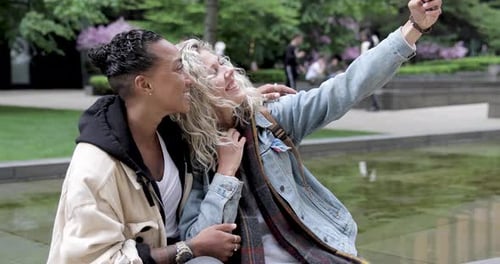 Happy mixed race girlfriends taking a selfie in London