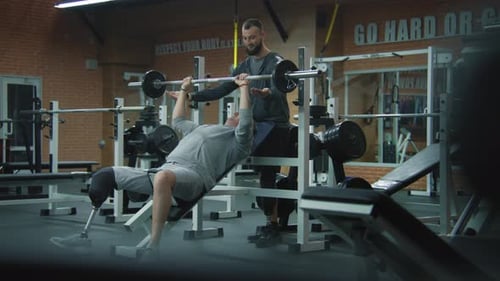 Man Working Out With Trainer at the Gym