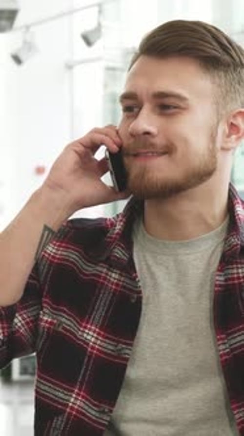 Young Adult Chatting on Smartphone Indoors