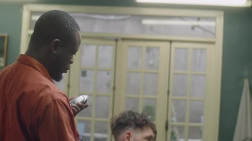 Barber Trimming Man's Hair in Barbershop