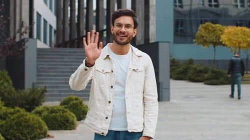 Indian Man Smiling Friendly at Camera Waving Hands Hello Hi Greeting or Goodbye in City Street