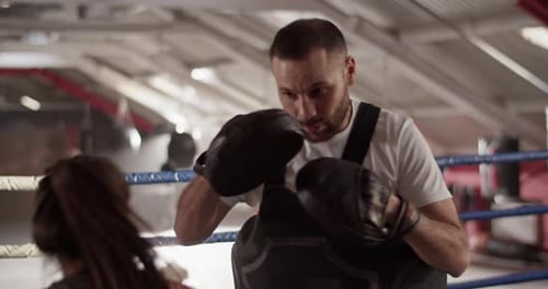 Boxing Coach Training Female Boxer in Ring