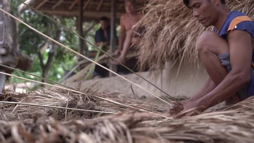 Men Weaving Thatched Roof in Rural Setting