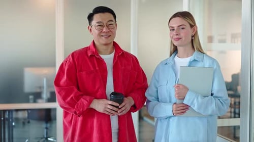 Femme tenant un ordinateur portable et homme appréciant une tasse de café debout dans une armoire