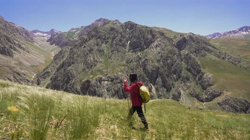 Woman Hiking Through Mountain Valley on Sunny Day
