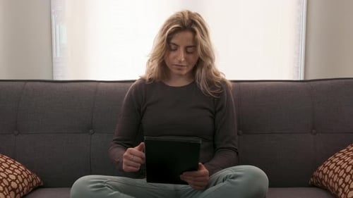 Young Woman Using Tablet Relaxing On Couch