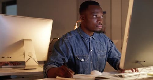 4k video footage of a handsome young businessman working at night in a modern office