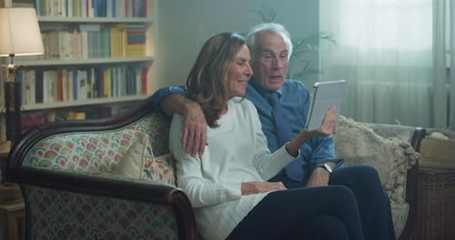 Cinematic shot of happy smiling modern mature senior couple is having fun to make selfie or techno