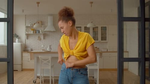 Irritated Black Woman Struggling to Fit Into Small Jeans After Gaining Weight