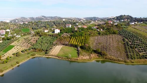 Aerial above lake Golemit and agricultural fields in Golem, Albania.