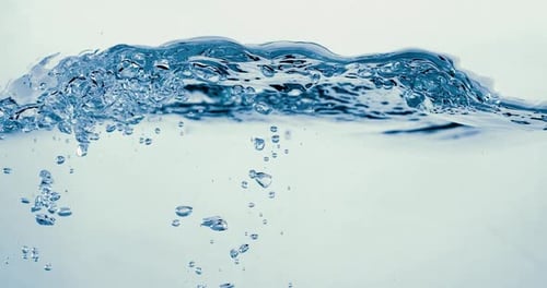 Many bubbles in water close up, abstract water wave with bubbles in slow motion