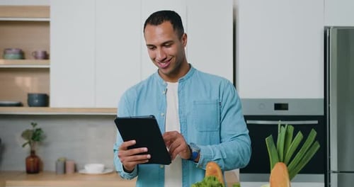 Man Uses Tablet in Bright Modern Kitchen