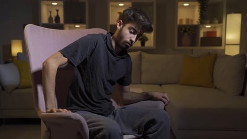 Young Man in Chair Expressing Intense Emotions