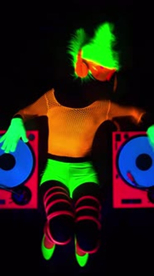 Woman Performing as a DJ in Neon Lighting