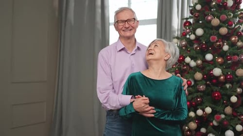 Happy Senior Couple Hugging Near Christmas Tree