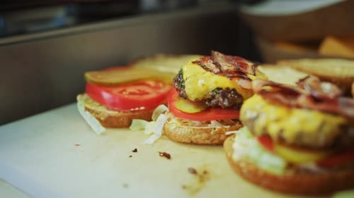 Tasty Close Up Footage of a Cook Preparing Burgers. Food Chef is Adding a Flaming Hot Grounded Beef