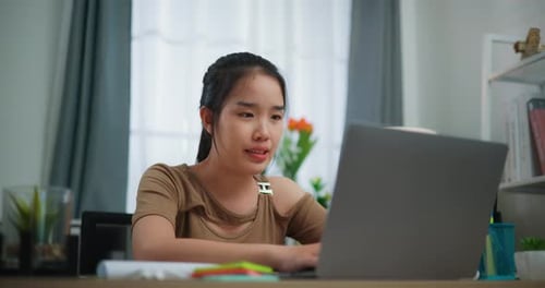 Young Woman Using Laptop at Home Desk