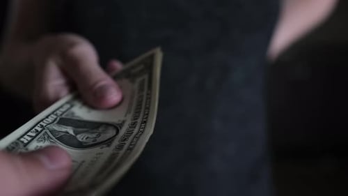 Nahaufnahme einer Hausfrau, die ihrem Mann eine Packung Euro-Banknoten überreicht, wütende Hausfrau