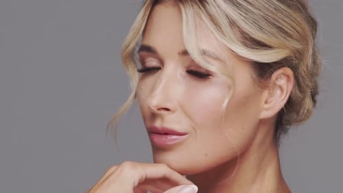 Studio Portrait of Young and Beautiful Blond Woman Over Grey Background Skin Care and Wellness