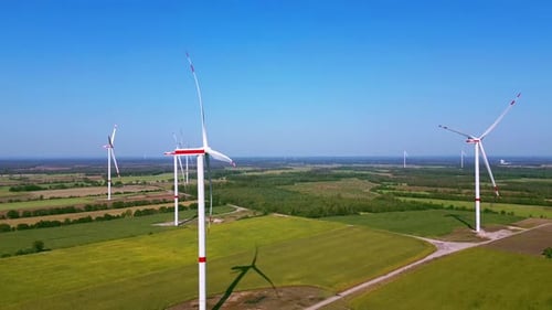 Wind Turbines Spinning in Rural Landscape on Sunny Day