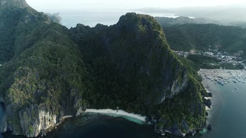 Aerial Drone Shot of High Mountain Covered with Tropical Forest and Boats Anchored in the Bay