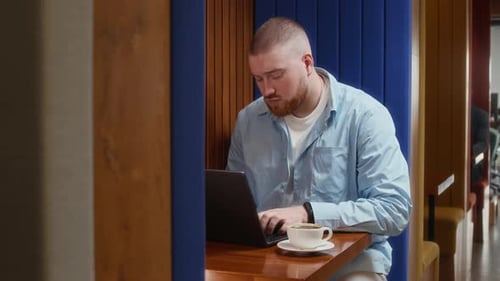 Young Adult Working on Laptop in Modern Office