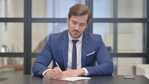 Junger Geschäftsmann schreibt einen Brief im Amt