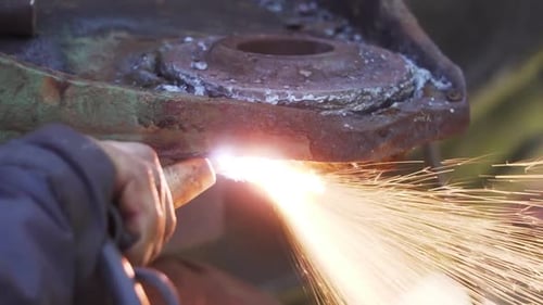 Craftsman Cutting Rusted Part Of A Metal Disc With A Blowtorch In A Workshop - close up slowmo