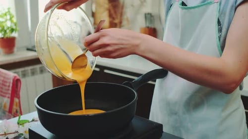 Person Preparing Omelet in Kitchen
