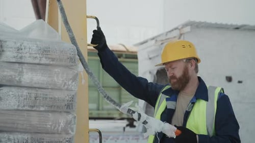 Bearded Factory Worker Using Lifting Hoist