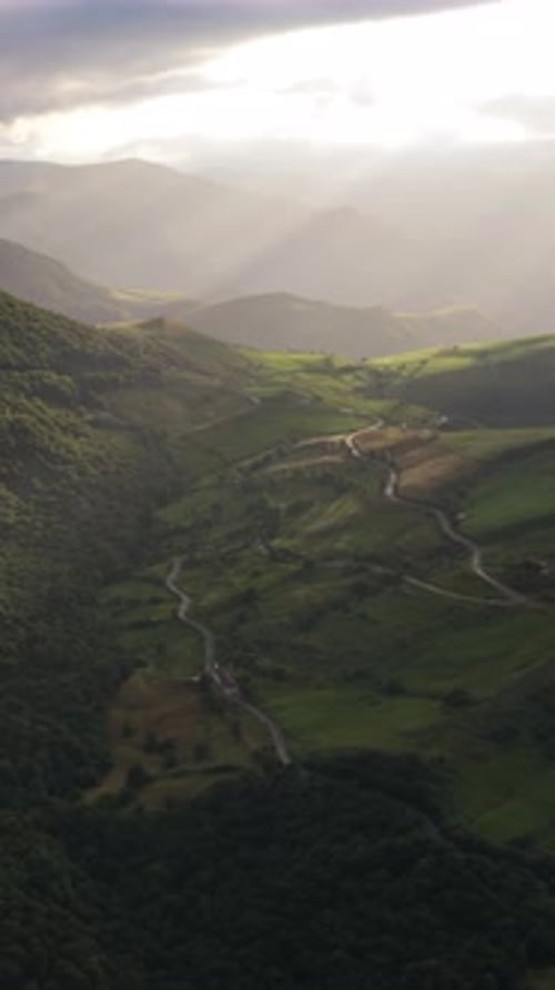 Mountain Landscape Aerial View with Winding Road and Sun Rays Vertical